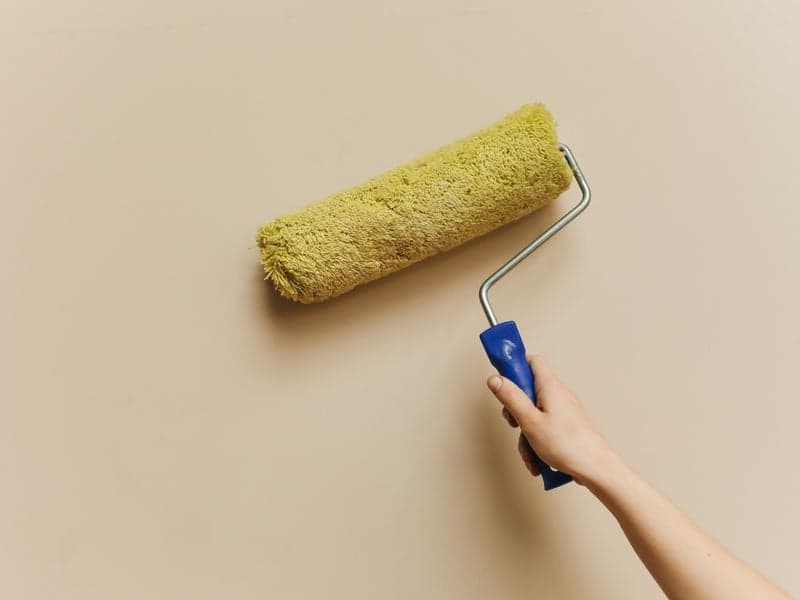 Rouleau de peinture appliqué sur un mur intérieur